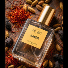Load image into Gallery viewer, Amor, A premium warm spicy unisex perfume — 50ml clear glass bottle with gold cap — saffron, cardamom,  tonka beans amd agarwood A rich woody fragrance — EsQue Parfum — styled with saffron threads, cardamom pods &amp; dried fruits on dark wood