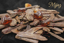 Load image into Gallery viewer, Stack of dried herbs with amber-colored resin on a dark background, featuring the brand 'Mijaz'. Woody - warm Oud for men and women 
