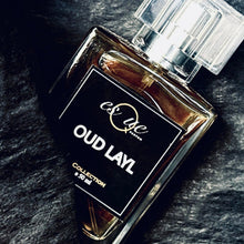 Load image into Gallery viewer, Oud Layl. A  premium rich warm oud perfume,  50ml black &amp; gold bottle. Blend is cinnamon, liquorice, vanilla &amp; amber fragrance — EsQue Parfum — styled on dark textured surface